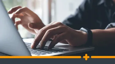 Mężczyzna w czarnym ubraniu pracujący na laptopie